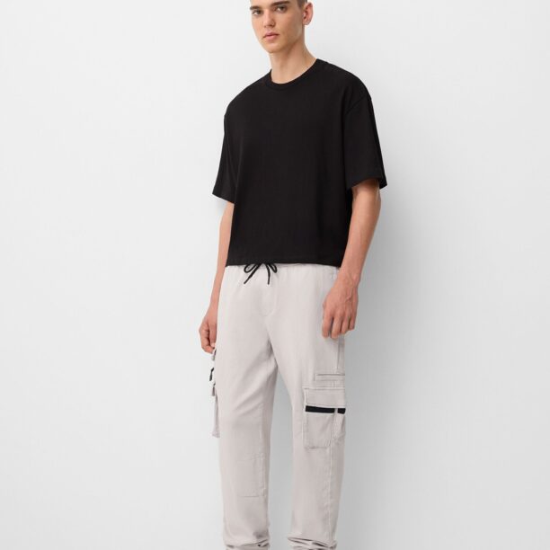 Cumpăra Bershka Pantaloni cu buzunare  gri deschis / negru