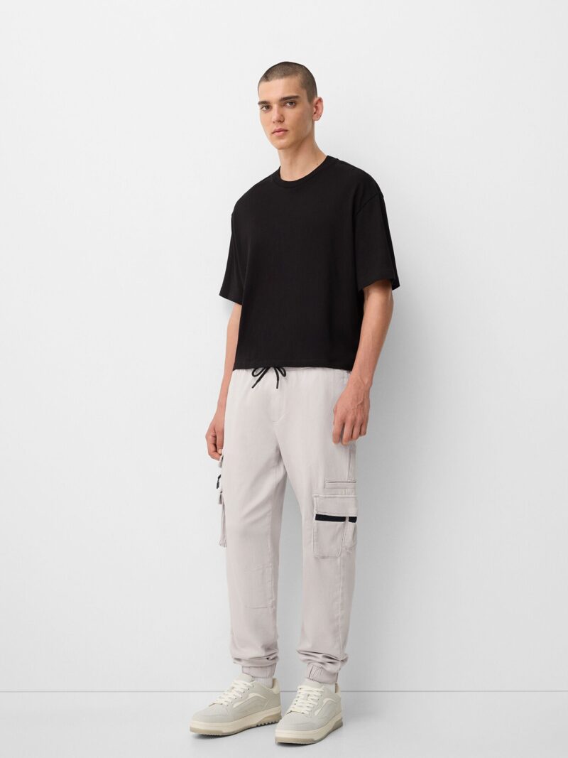 Cumpăra Bershka Pantaloni cu buzunare  gri deschis / negru